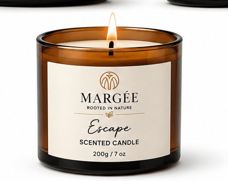 MARGÉE Escape Scented Candle, lit candle in amber glass jar